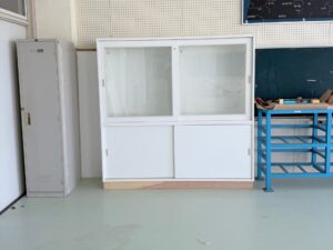 理科室に設置した強化ガラス引き戸付きの白い実験器具入れ